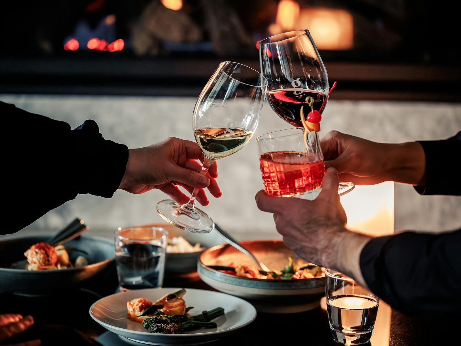 Friends enjoying drinks fireside in hotel lounge